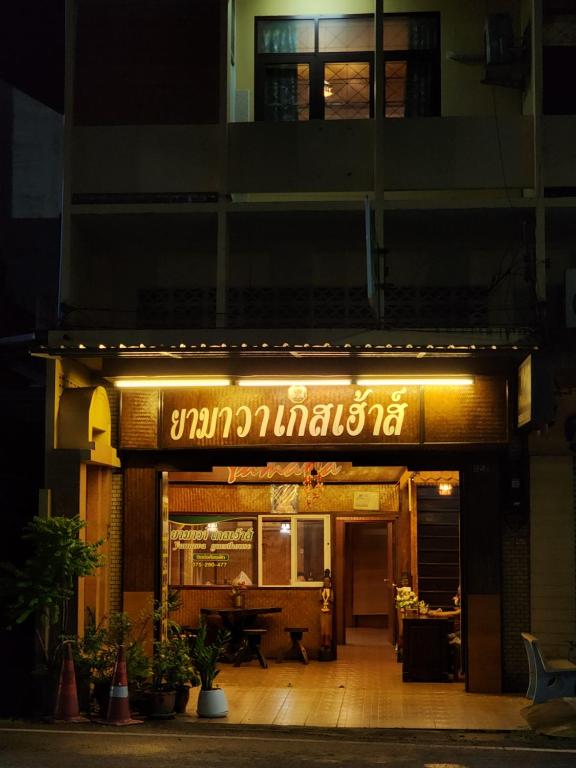 董里Yamawa Guest House ยามาวาเกสเฮ้า的一座有夜间餐厅标志的建筑