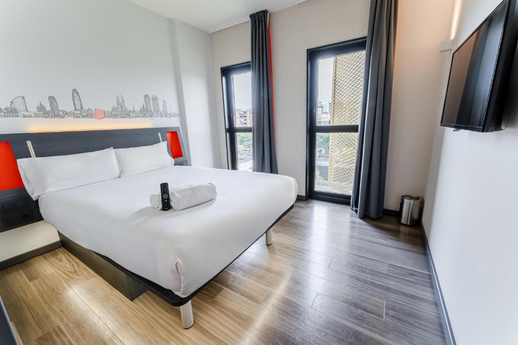 略夫雷加特河畔奥斯皮塔莱特easyHotel Barcelona Fira的卧室里有一张白色的大床和一台电视