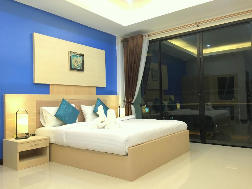 沙美岛萨姆德港旅舍的一间卧室配有一张带蓝色墙壁的大床