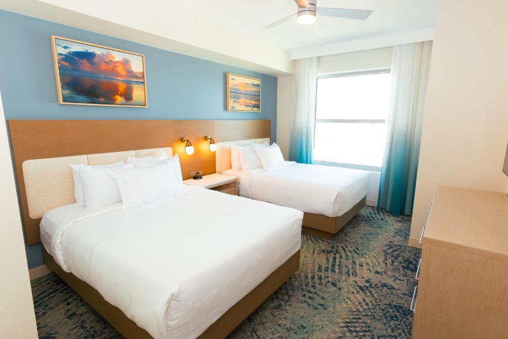 默特尔比奇Holiday Inn Club Vacations Myrtle Beach Oceanfront的有两张床和一扇窗户的酒店房间