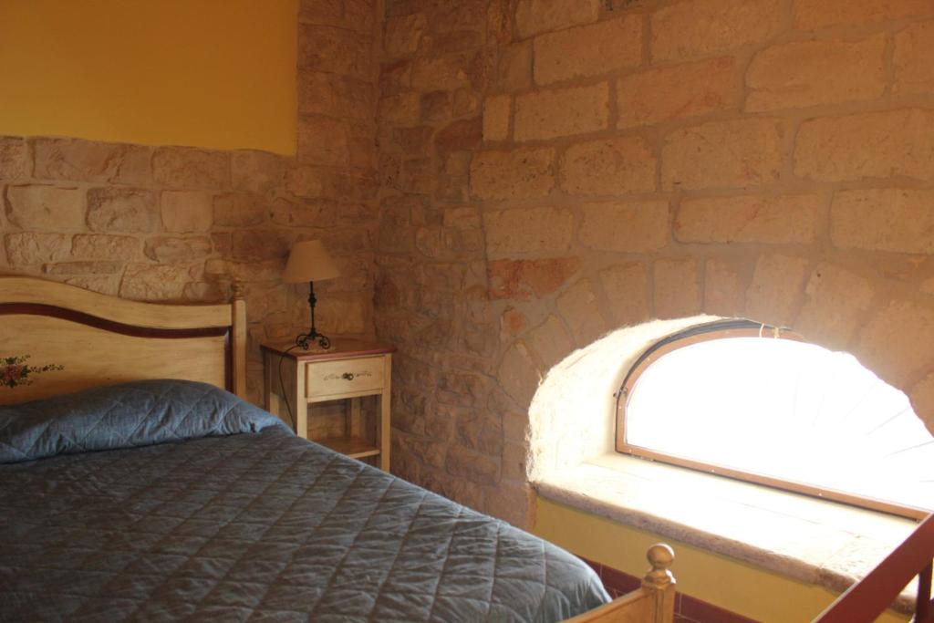 比谢列Case Vacanza ARCO SANT'ANTONIO的卧室设有砖墙、床和窗户