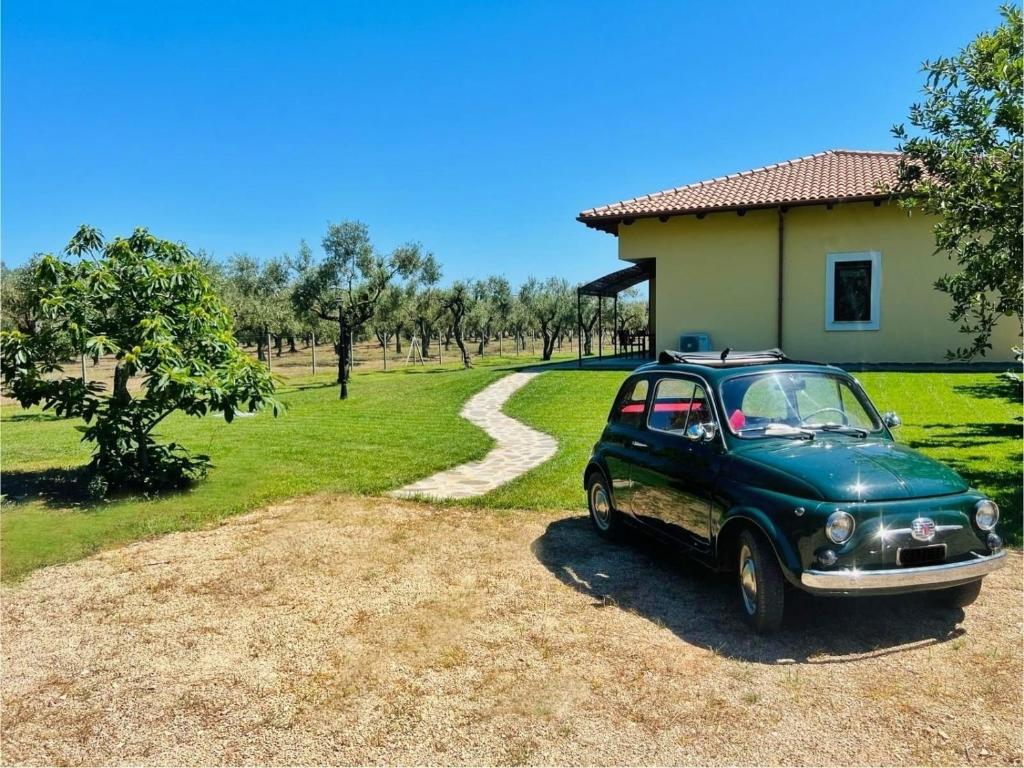 阿尔盖罗Agriturismo Il Podere Alghero的停在房子前面的绿色汽车