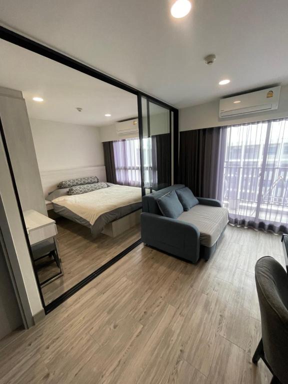 华欣DusitD2 Hua Hin 2- One bedroom with a beautiful view 8的一间卧室配有一张床、一张沙发和一面镜子