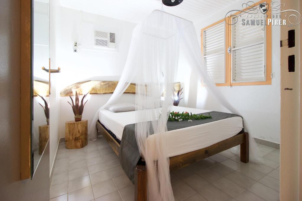 圣安娜Orcéa & Spa Séjours Ecofriendly的一间卧室配有一张带蚊帐的床