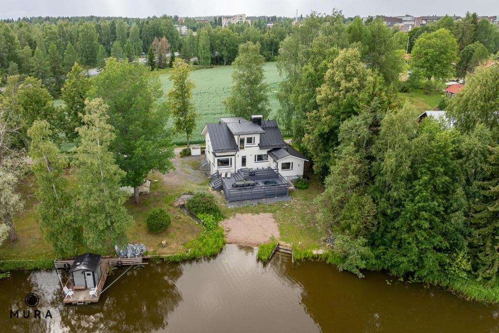 伦派莱Villa Gaia - Luxury villa with jacuzzi and beach next to trainstation 10 minutes to Tampere city! 1,5 hours to Helsinki的水面上岛上房屋的空中景观