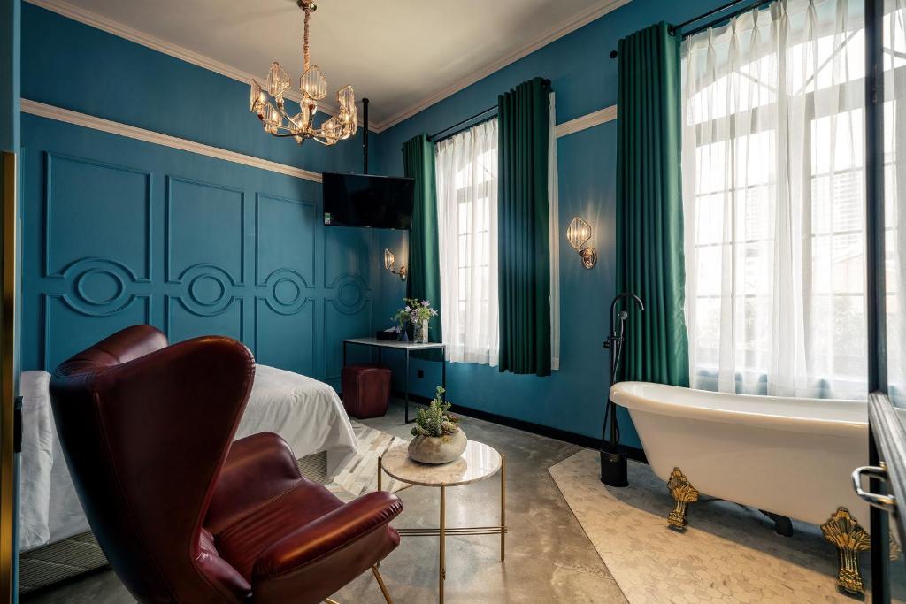胡志明市HOTEL le JARDIN SECRET saigon的一间带蓝色墙壁、浴缸和床的浴室