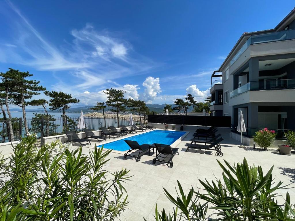 希洛Villas Punta Silo - luxury apartments with pool的一座带躺椅的游泳池和一座建筑