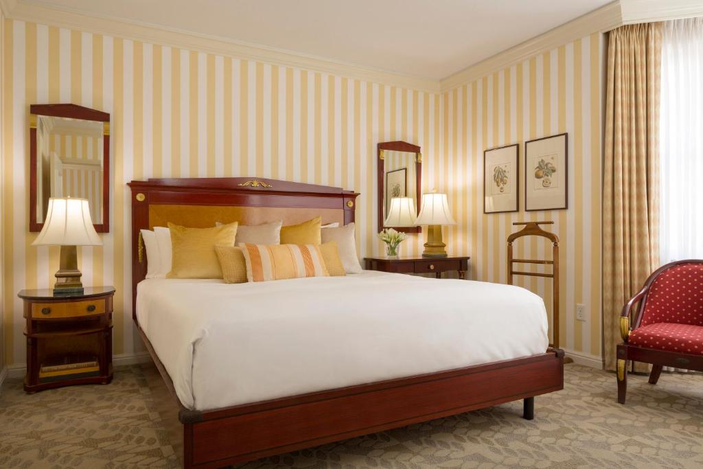 旧金山旧金山乌节大酒店的一间卧室配有一张大床和一张红色椅子