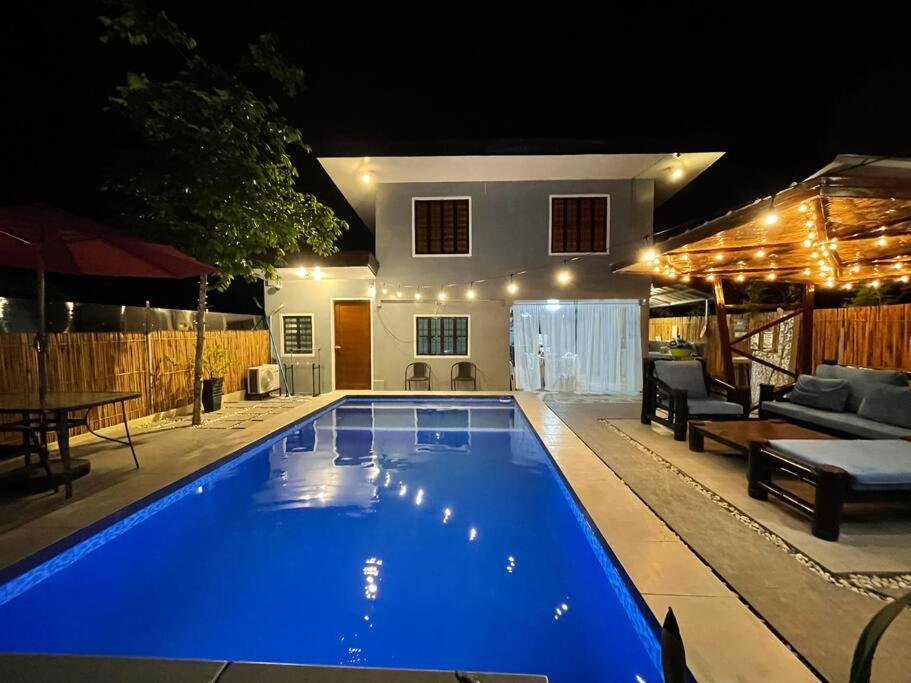 BabakVacation Home with Private Pool in Samal Island的夜间在房子前面的游泳池