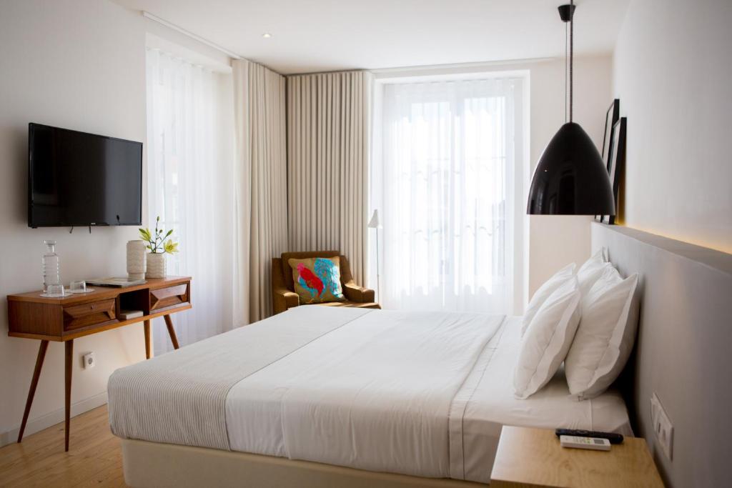 里斯本8号市区套房酒店的卧室配有白色的床和窗户。