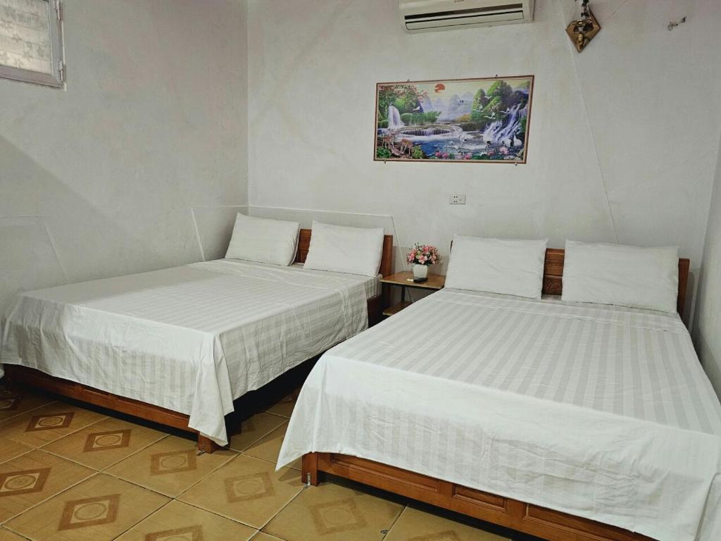 洞海Homestay 117 Bà Triệu - Đồng Hới的两张睡床彼此相邻,位于一个房间里