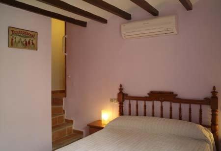 菲内斯特拉特Casa Figueretes的一间卧室配有一张床和一张桌子上的台灯