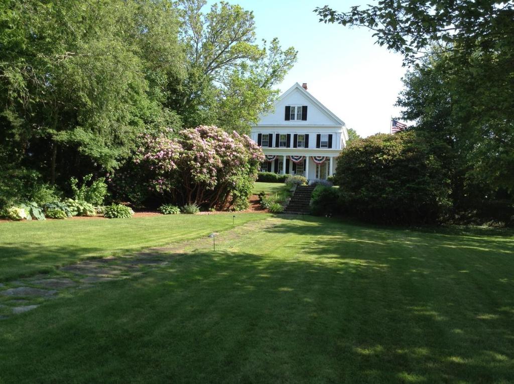雅茅斯Liberty Hill Inn的白色的房子,有大院子,有树木