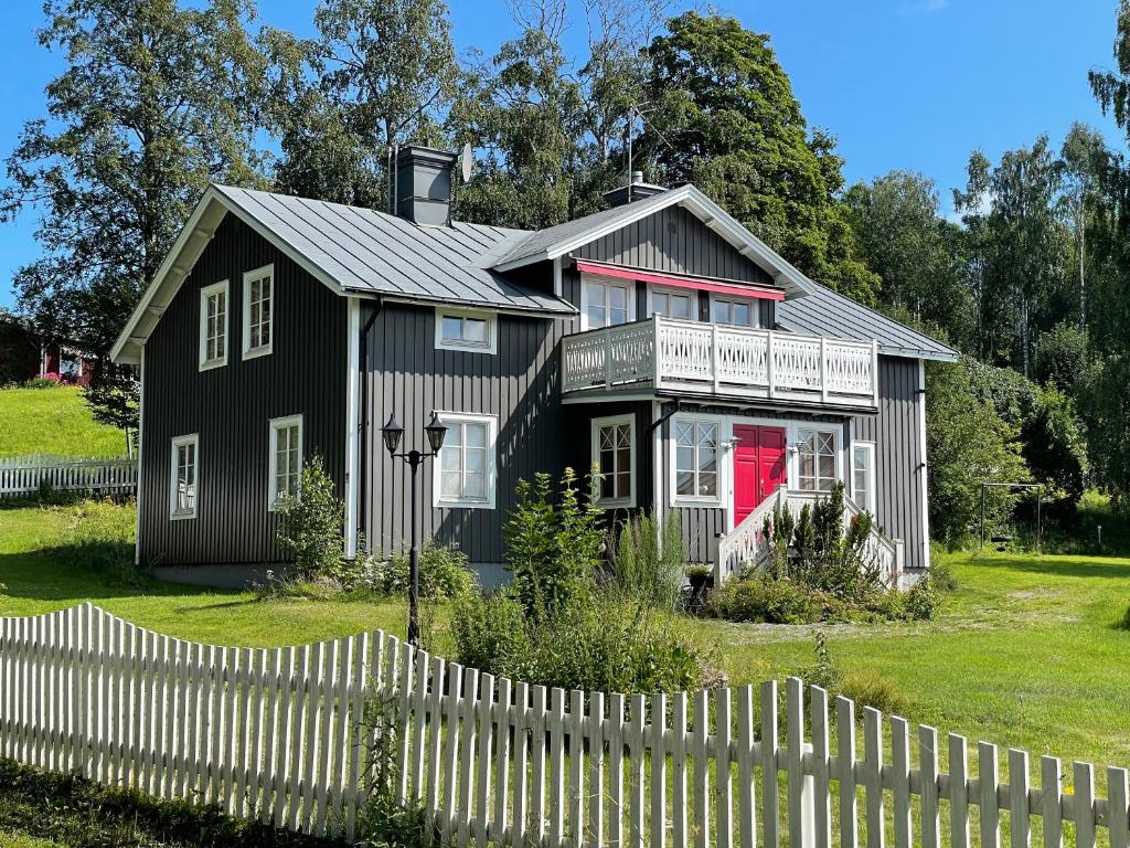 TimråTimrå Farmhouse的前面有白色围栏的黑色房子