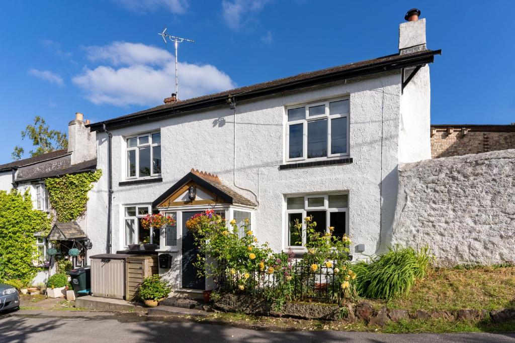 廷茅斯Haldon View - Characterful Devon cottage boasts stunning countryside views and hot tub的前面有鲜花的白色房子