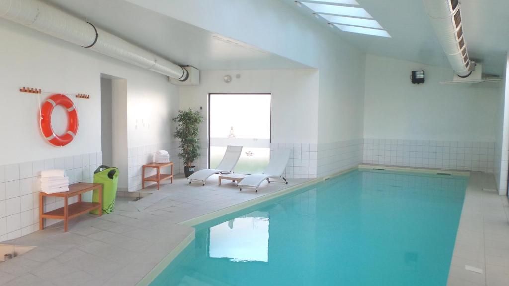 圣路易圣路易巴塞尔阿德吉奥阿克瑟斯公寓式酒店的游泳池位于带游泳池的白色客房