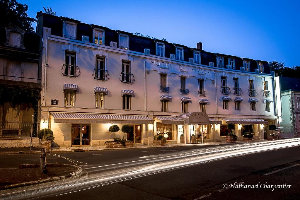 日安Logis Hôtel Le Rivage的夜行的街道上一座白色的大建筑