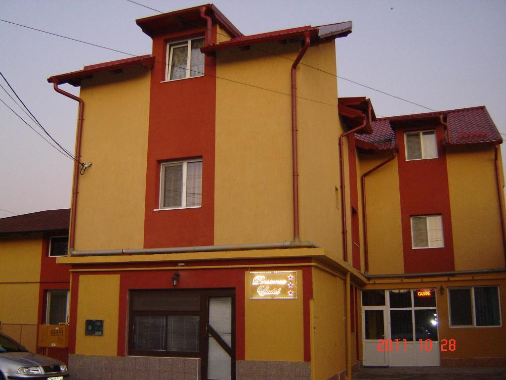 蒂米什瓦拉Pensiunea Vladut Timisoara的一座黄色和红色的大房子,设有车库