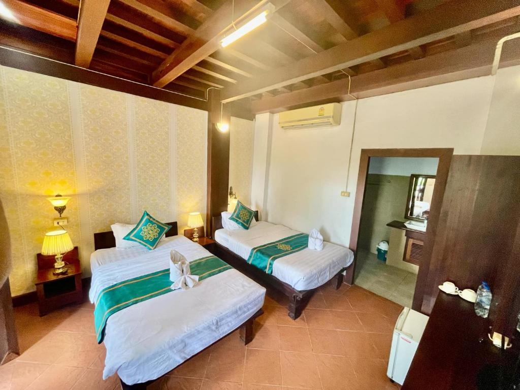 琅勃拉邦Luang Prabang Charming Boutique Hotel的带两张床和镜子的客房