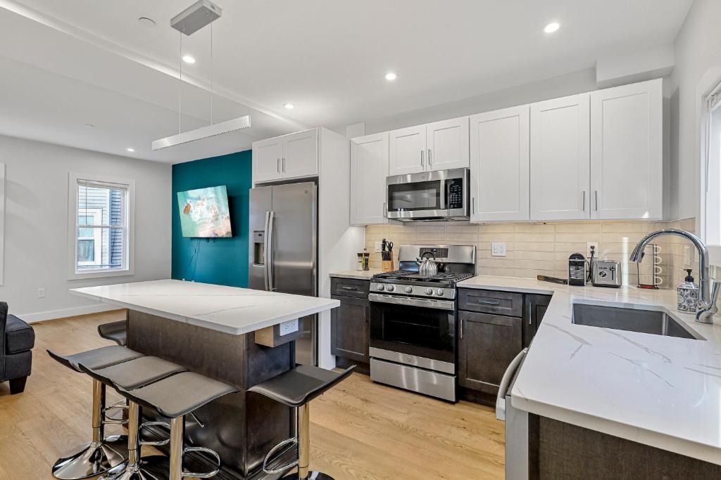 萨默维尔3BR2Bth MIT Harvard TD Garden BOS 2 Parking Spaces的配有白色橱柜和不锈钢器具的厨房