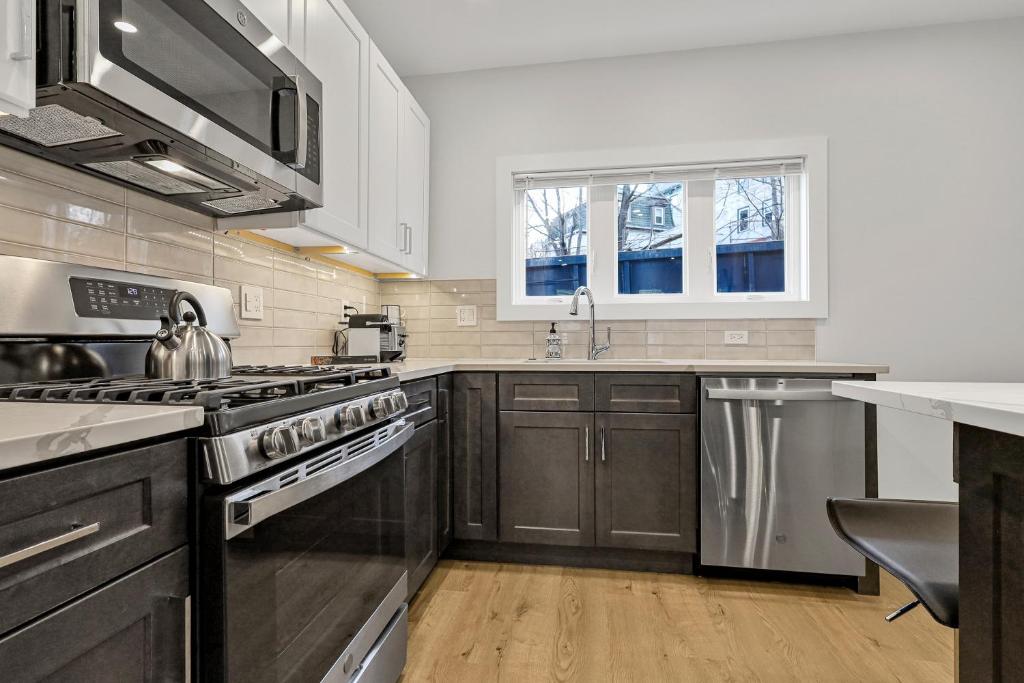 萨默维尔3BR2Bth MIT Harvard TD Garden BOS 2 Parking Spaces的厨房配有不锈钢用具和木柜