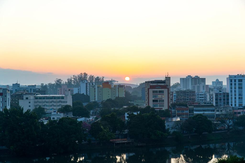 雷森迪Hotel Vila Rica Flat的城市天际线,背景是日落