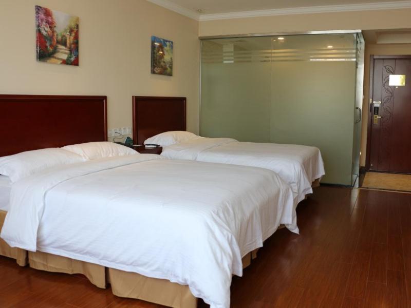 苏州格林豪泰江苏省苏州市相城活力岛商务酒店的配有白色床单的酒店客房内的两张床
