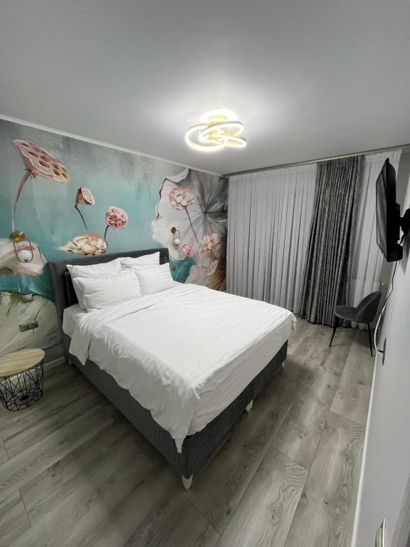 锡比乌Glam Studios的卧室配有一张床,墙上挂有绘画作品