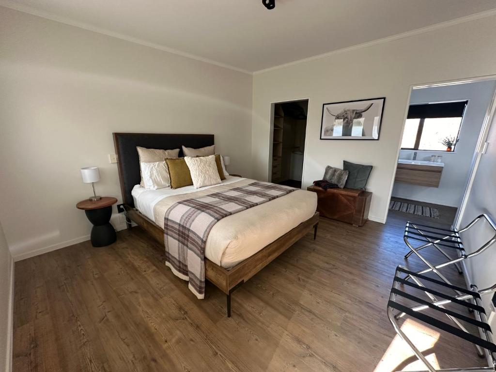 亚历山德拉Cariad Apartment的一间卧室配有一张床,铺有木地板