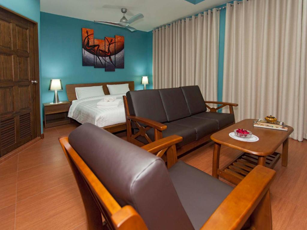 南芭堤雅芭堤雅花园公寓精品酒店的酒店客房配有床、沙发和桌子。