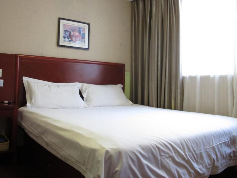 舟山格林豪泰浙江省舟山市新城商务酒店的一张位于酒店客房的床铺,设有大窗户