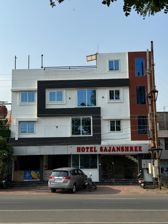 印多尔Hotel Sajanshree的前面有停车场的酒店