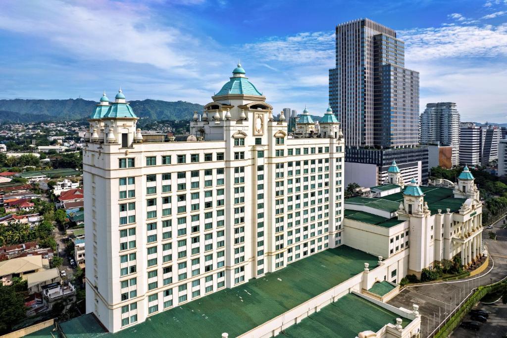 宿务Waterfront Cebu City Hotel & Casino的享有大型白色建筑的空中景致,设有绿色屋顶