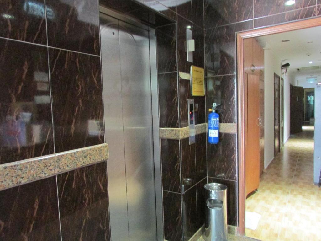 新加坡鄂梅兹旅馆的浴室设有玻璃门和瓷砖墙