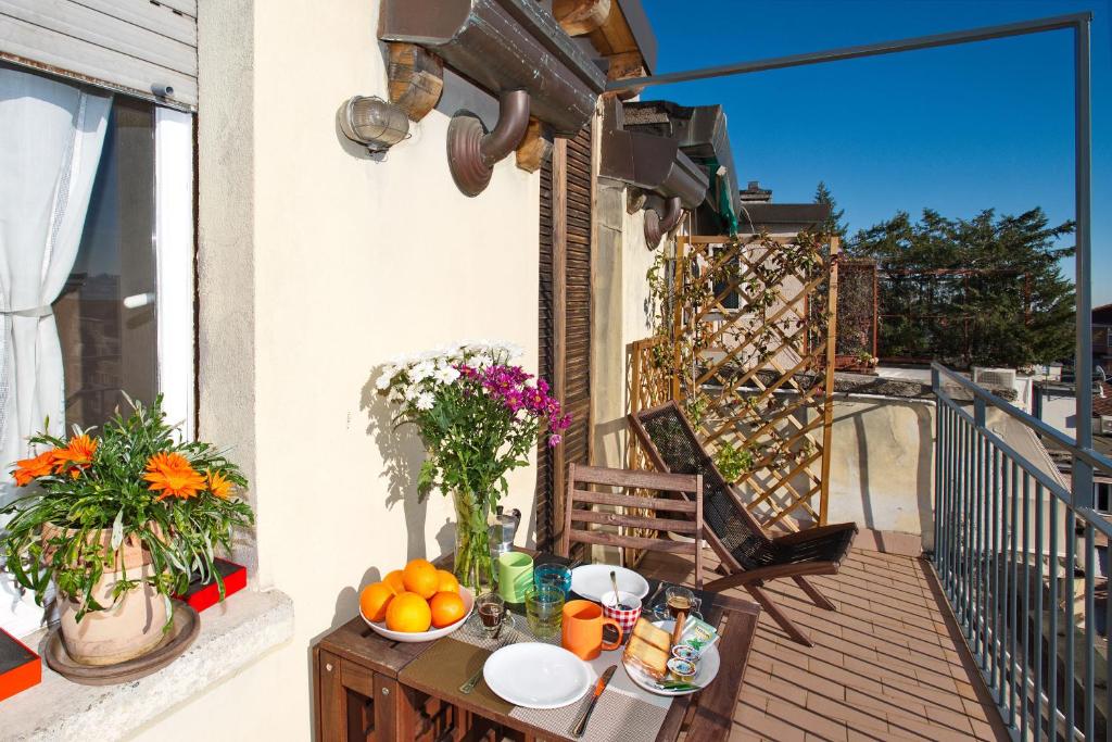 米兰Milan Skyline Apartment in città studi a 1 minuto dal metrò con terrazzo wi-fi e netflix的阳台上的桌子上放着橙子和鲜花