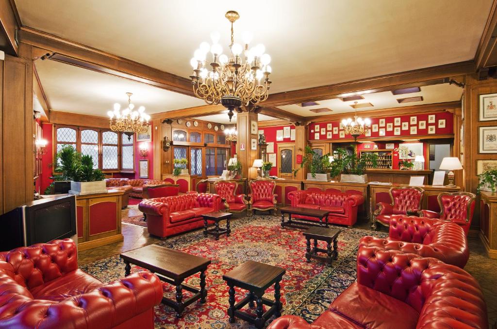 贝加莫齐塔德米雷酒店的大堂设有红色皮革家具和酒吧