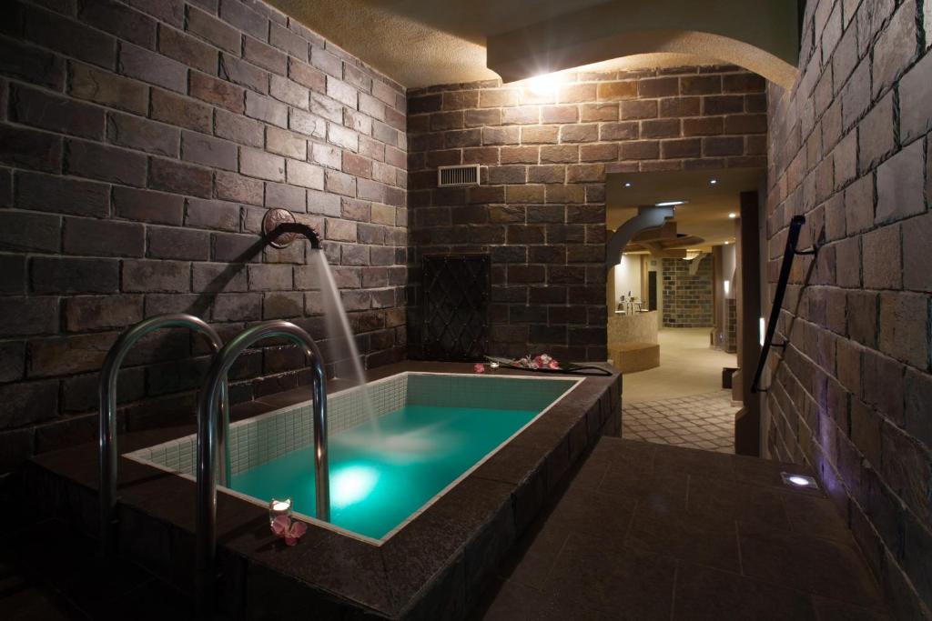 斯皮什新村梅特罗普尔酒店的砖墙内带浴缸的浴室