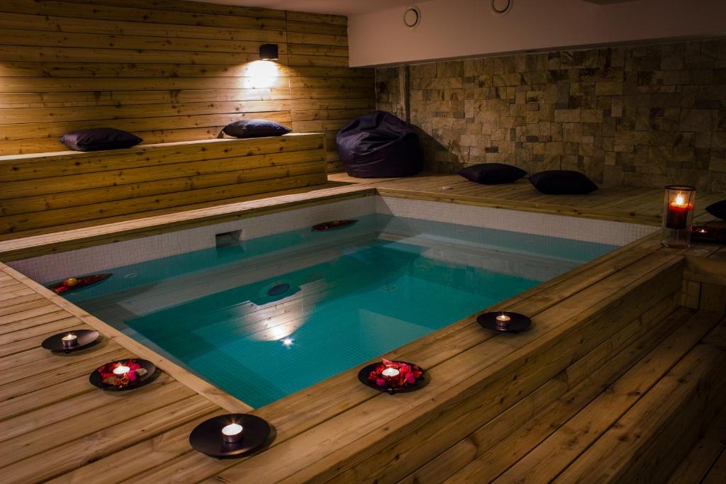 特里格拉德Trigrad Hotel的铺有木地板的客房设有一个按摩浴缸。