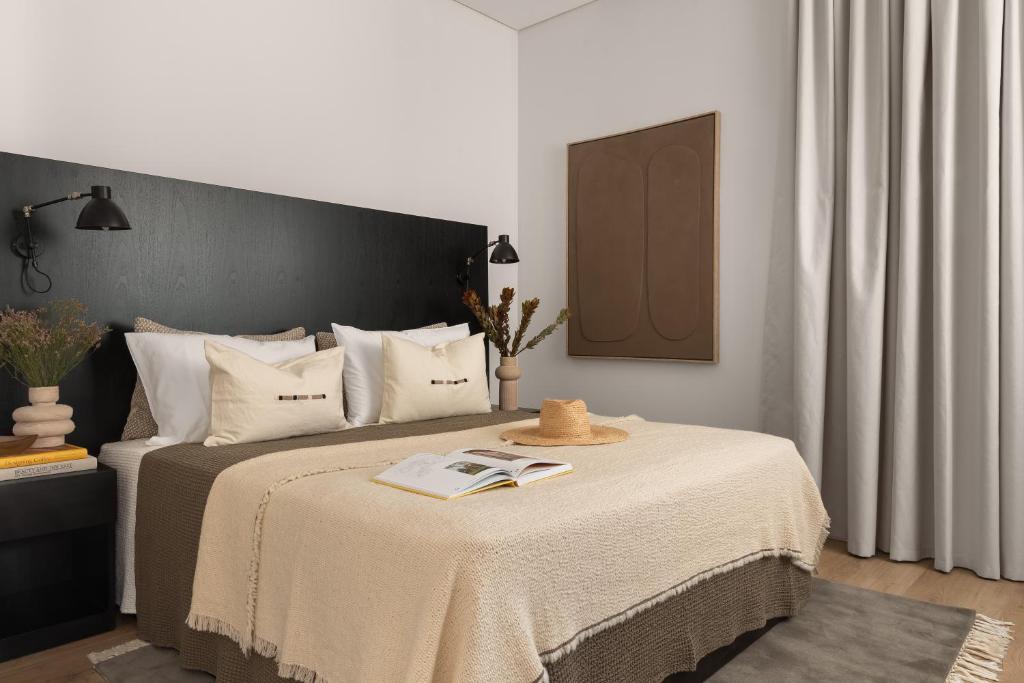 利马索尔White City Limassol Aparthotel的一间卧室配有一张床,上面有一本书