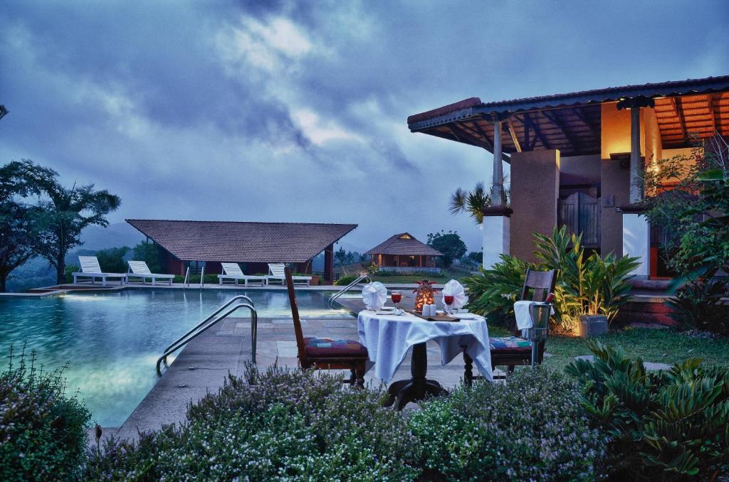 马迪凯里库格遗产度假酒店的游泳池旁的桌椅