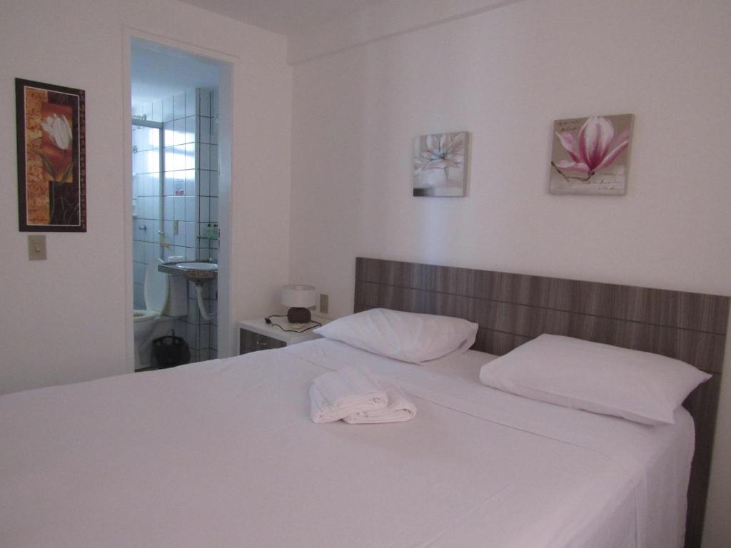 福塔莱萨Residencial em Meireles的一张带两个枕头的白色床和一顶帽子