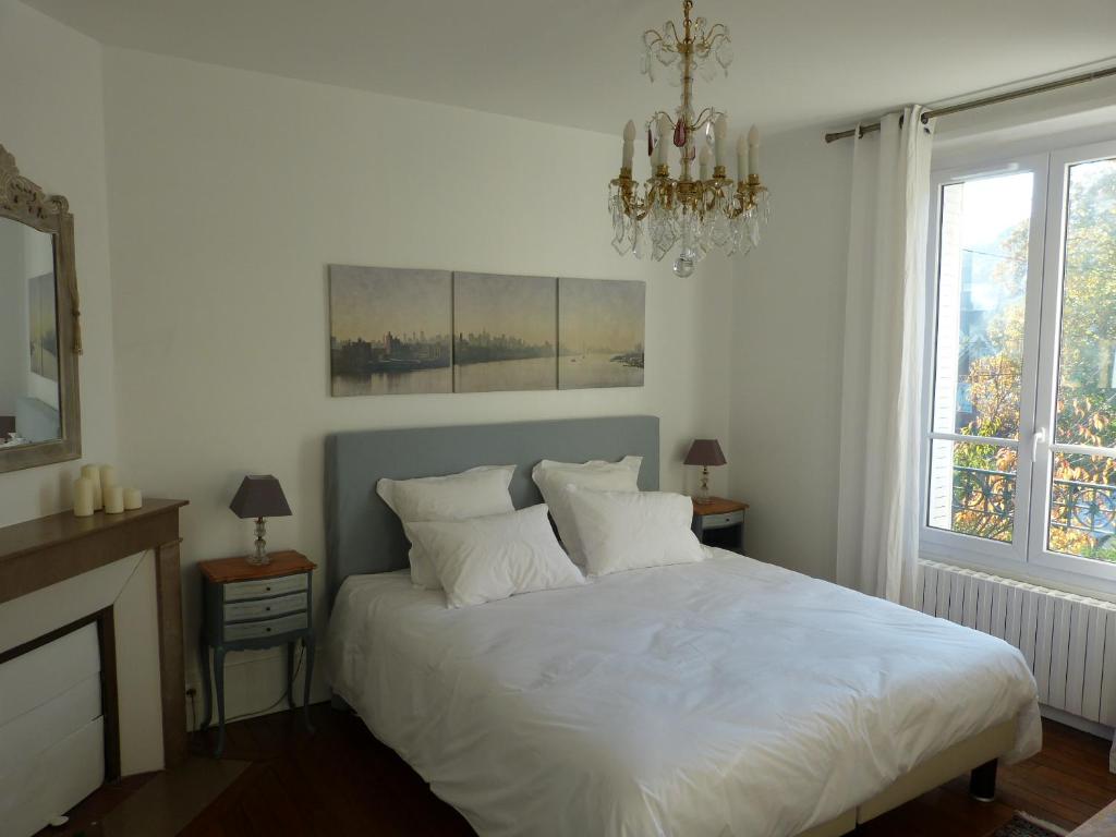 奥赛维拉博纳住宿加早餐旅馆的一间卧室配有一张带白色床单和吊灯的床。