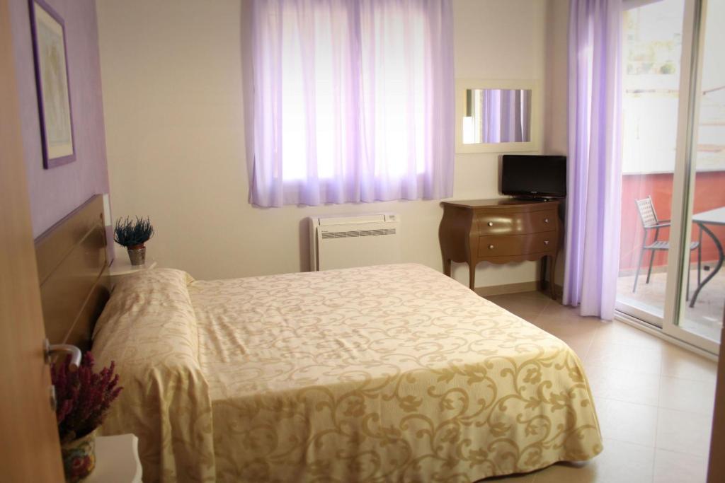 阿拉西奥Residence San Nicola的一间卧室配有一张床、一张书桌和一个窗户。