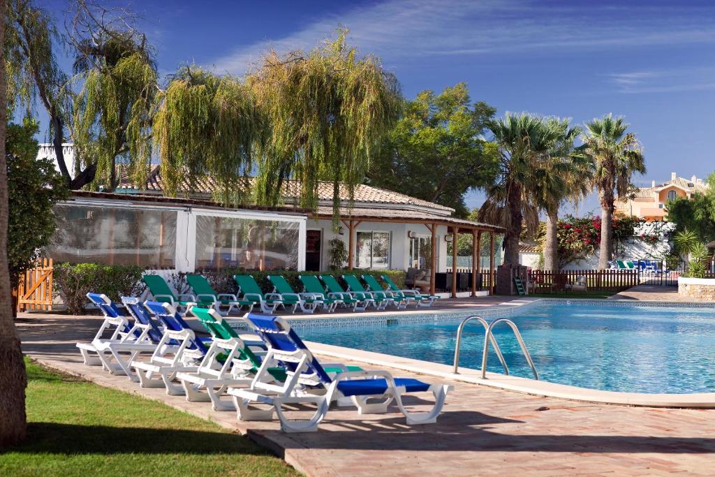 卢斯Luz Ocean Club Apartments的一组椅子坐在游泳池旁