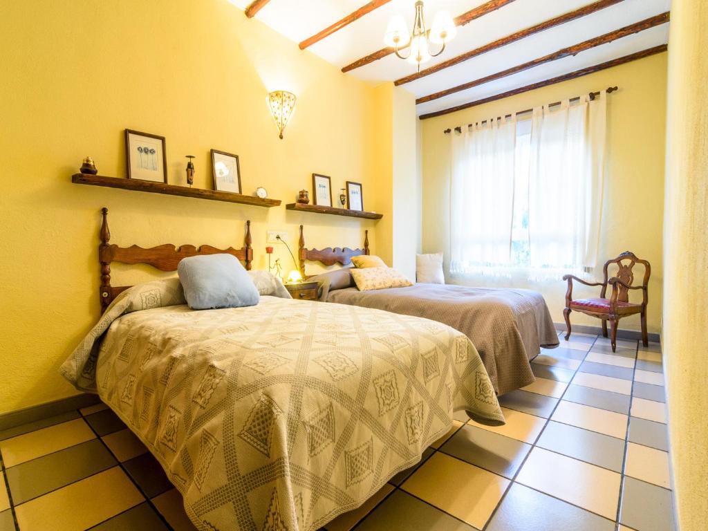 兰哈龙Lanjarón Rural Apartamentos的一间卧室设有两张床和窗户。