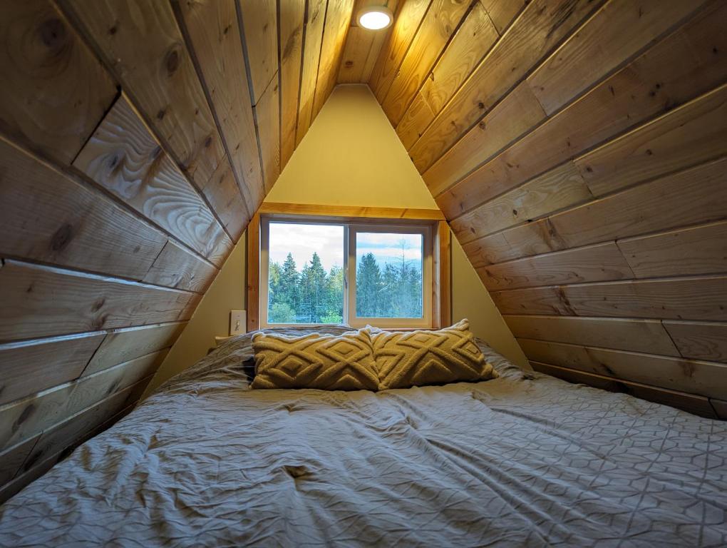 鲍威尔里弗Tree Ring Cabin on 33 Acres的一张位于带大窗户的房间内的床铺