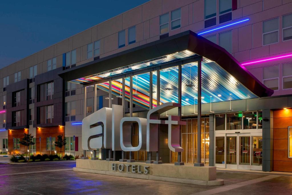 萨克拉门托Aloft Sacramento Airport Natomas的建筑前有标志的酒店