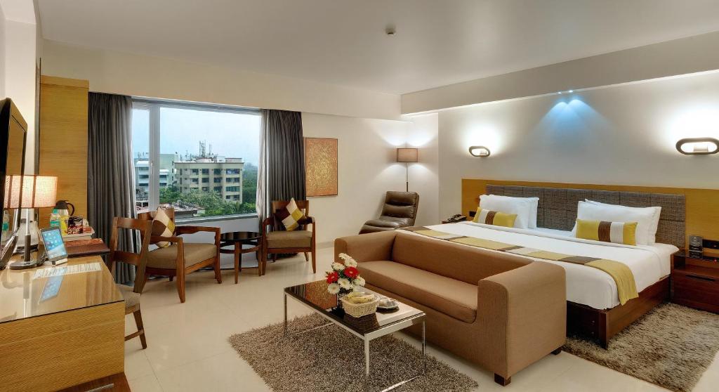 孟买速吧国际酒店的大型酒店客房,配有床和沙发