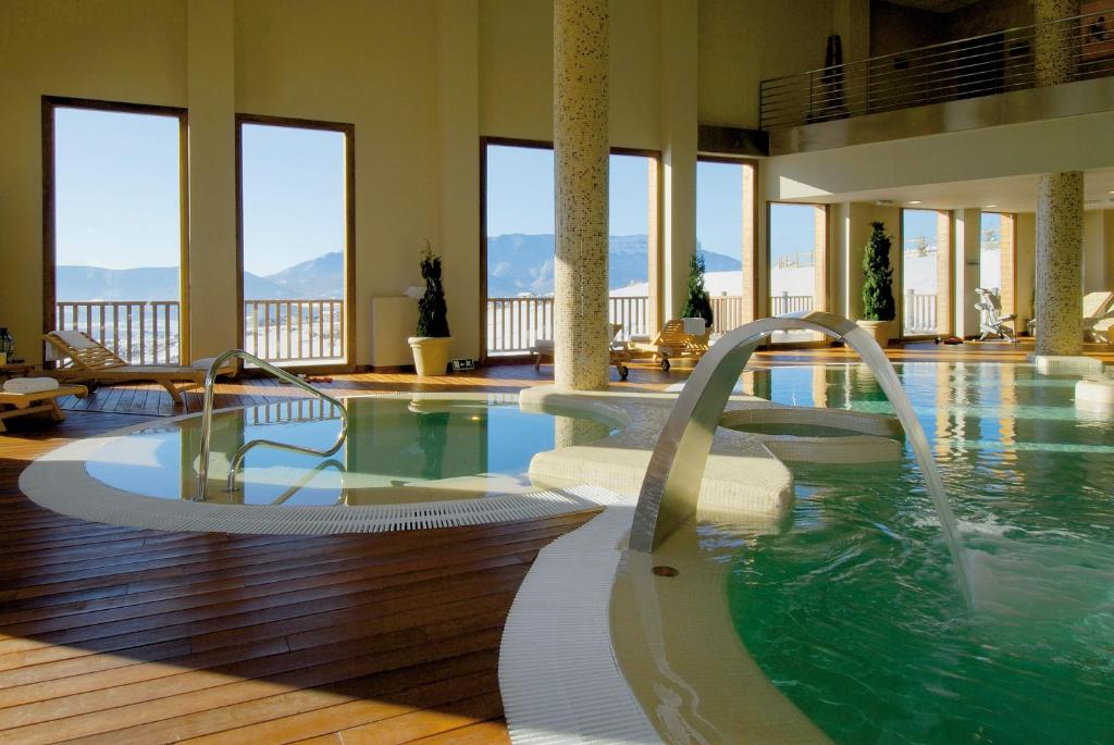 巴达古斯Hotel & Spa Real Badaguás Jaca的一座大楼内一个带两个水滑梯的游泳池