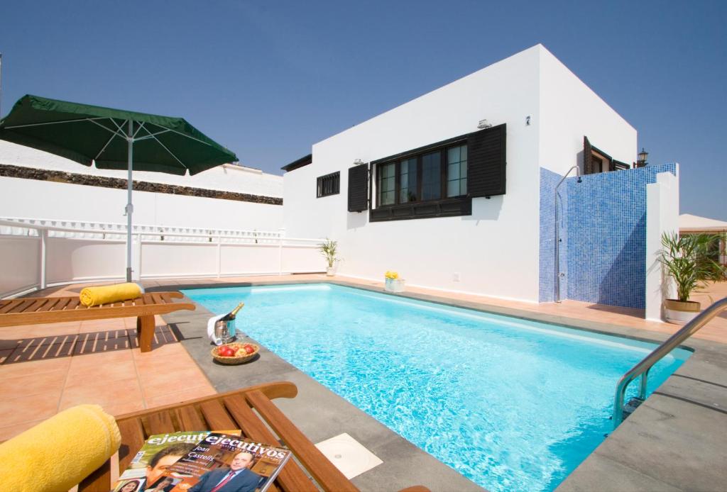 卡门港Grand Villa Famara Los Mojones by Dolores的一座带游泳池和房子的别墅